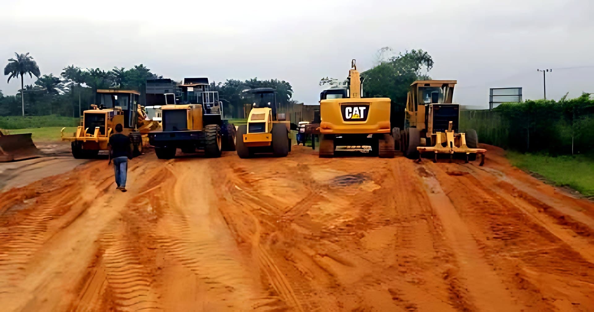 Graders, loaders and an excavator lined up on a road site